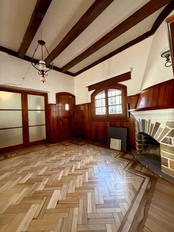 Estar con boiserie de madera y puertas vidriadas