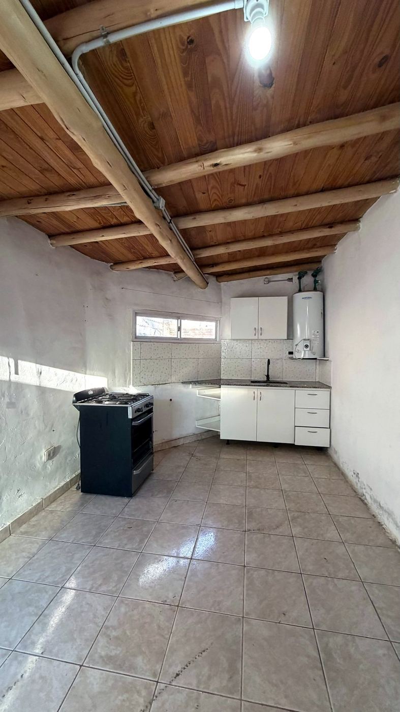 Cocina con techo de madera, muebles nuevos y mesada de granito