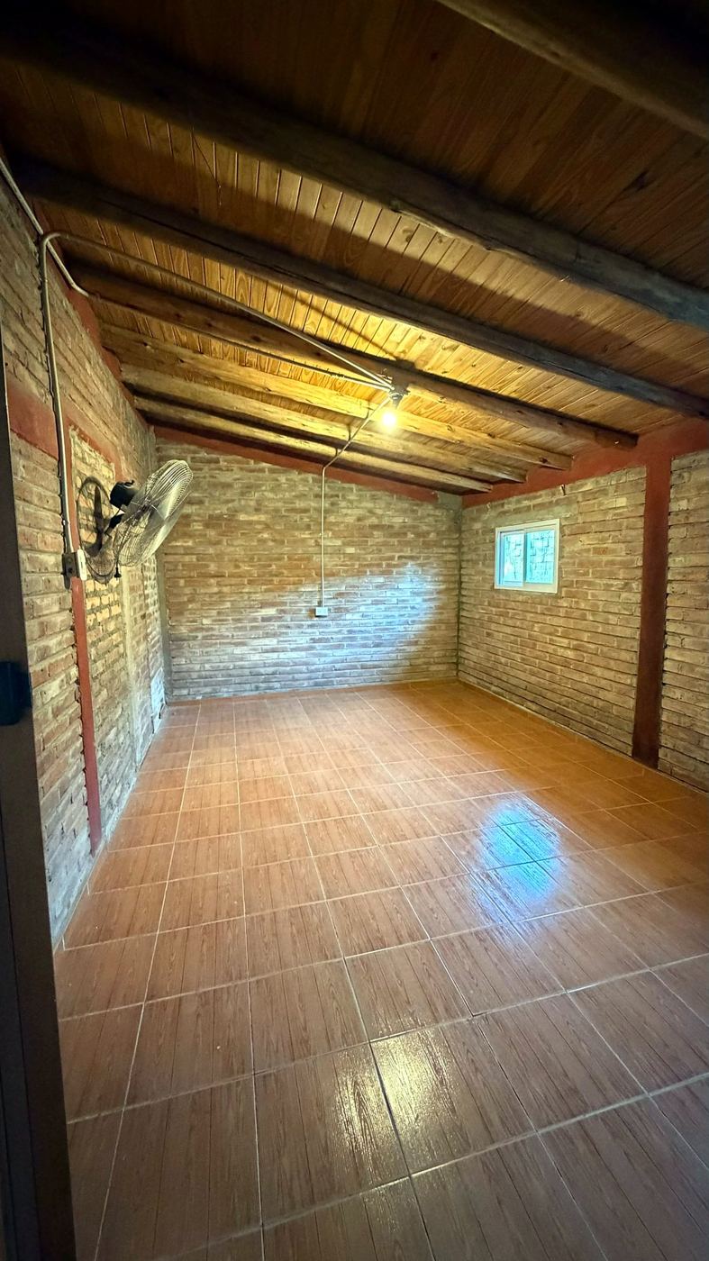 Ambiente con ladrillo visto, techo de madera y piso cerámico